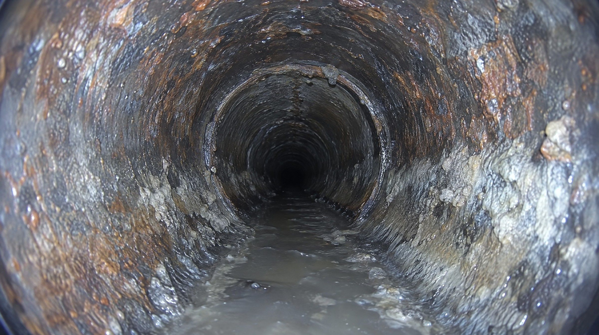 Vue caméra d'une canalisation en fonte couverte de tartre, de rouille et de graisse