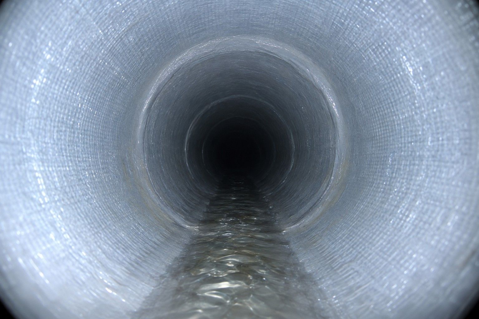 Intérieur d'une canalisation réhabilitée par chemisage, paroi en résine lisse et continue