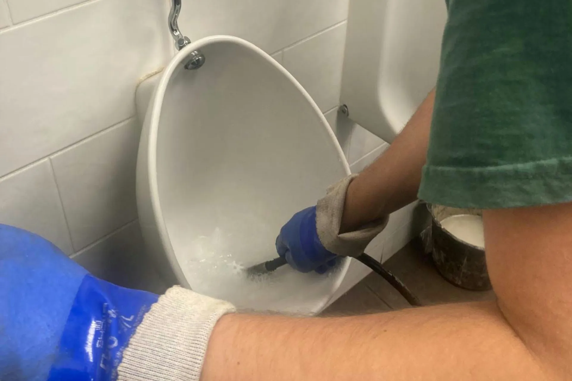 Technicien passant un furet dans la cuvette d'un WC