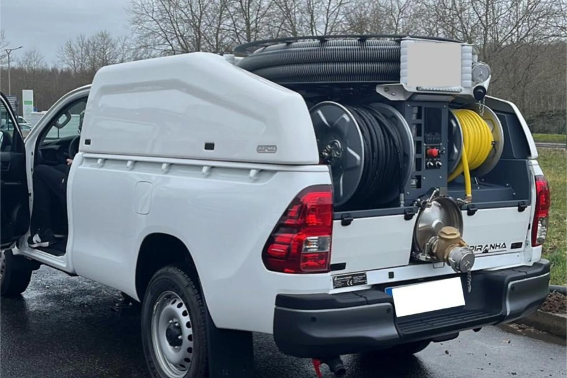 Pick-up blanc équipé d'une unité d'hydrocurage haute pression avec ses enrouleurs de flexible