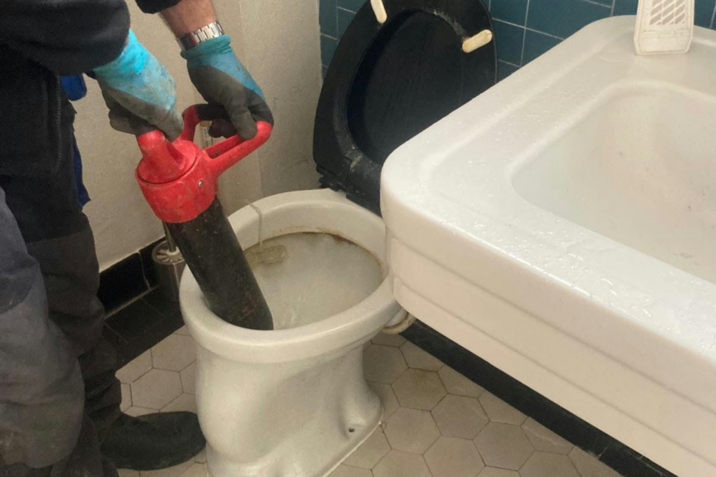 homme qui débouche des toilettes